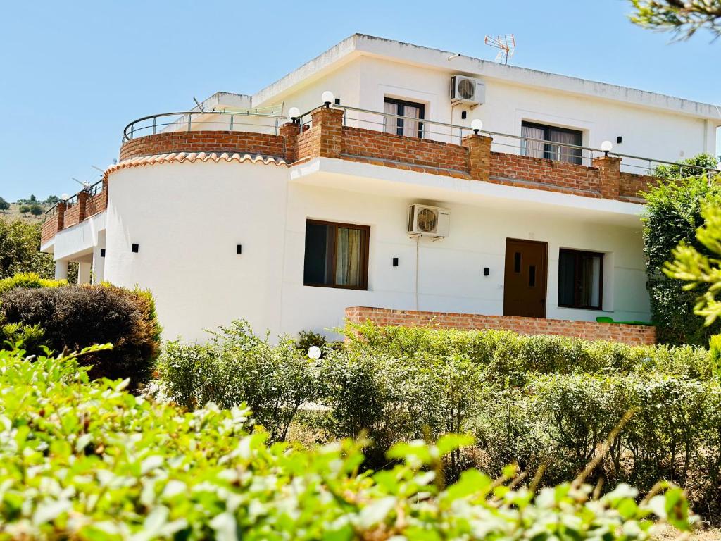 a white house with a balcony on top of it at Vila Demiraj Ksamil Sarande in Ksamil