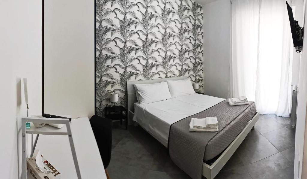 ein kleines Schlafzimmer mit einem Bett und einer Tapete in der Unterkunft A casa di Alma in Terni