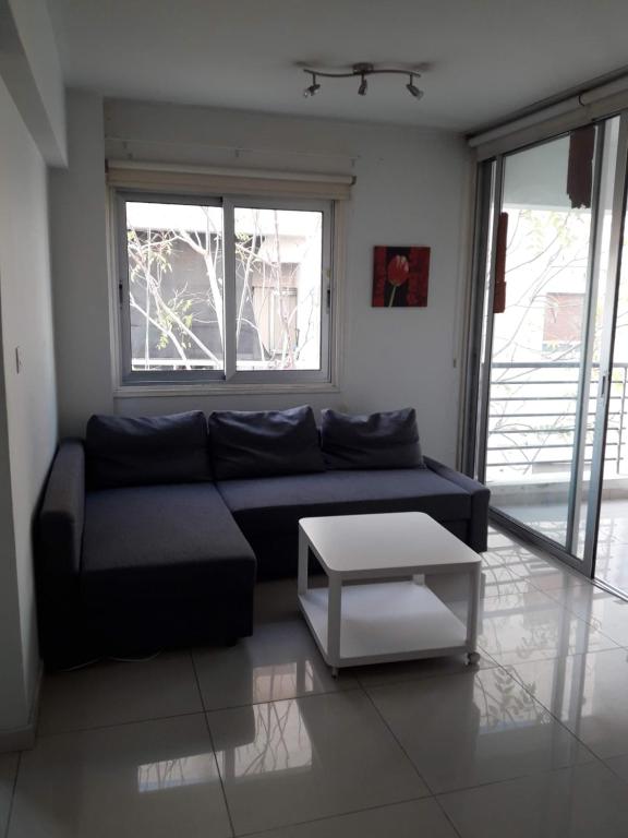 a living room with a black couch and a table at A MODERN APARTMENT FOR YOU in Nicosia