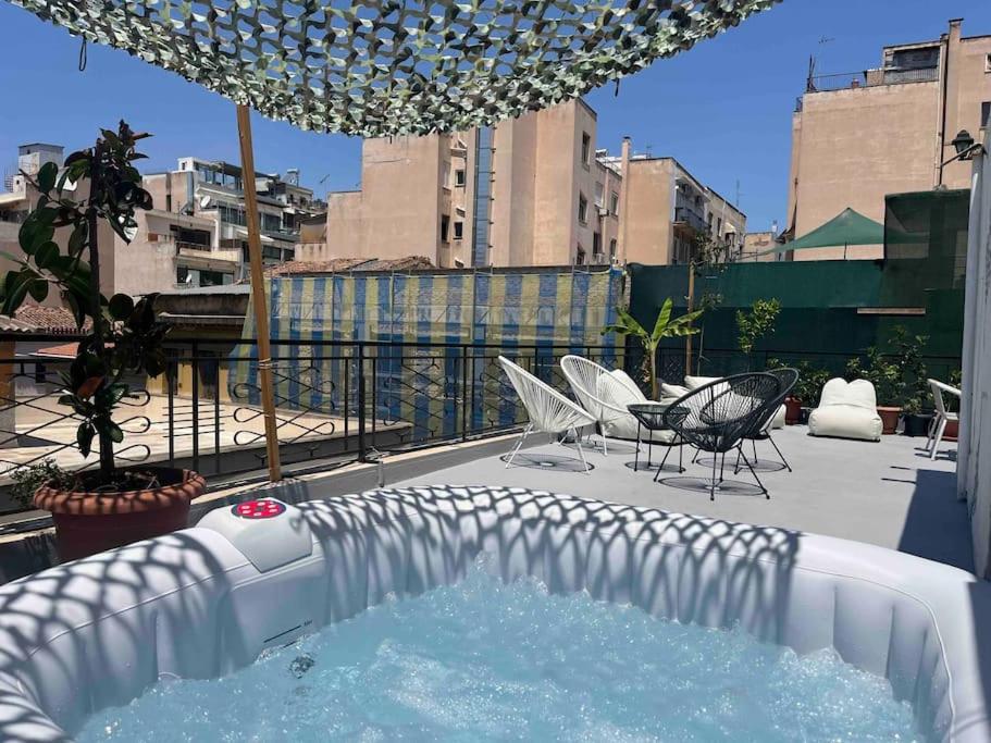 雅典的住宿－3BDR IDEAL CENTRAL ATHENIAN APT，阳台设有热水浴池、椅子和桌子