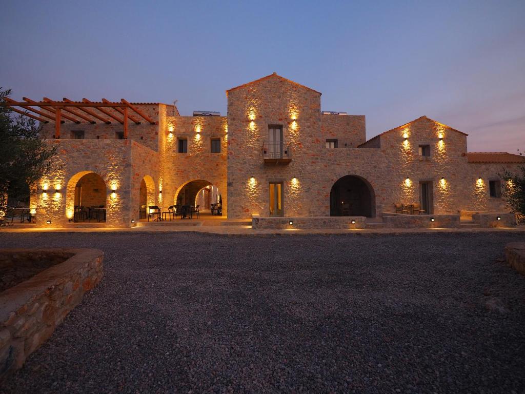 een groot bakstenen gebouw met 's nachts verlichting bij Terra Di Pietra Exclusive Suites & Apartments in Areopolis