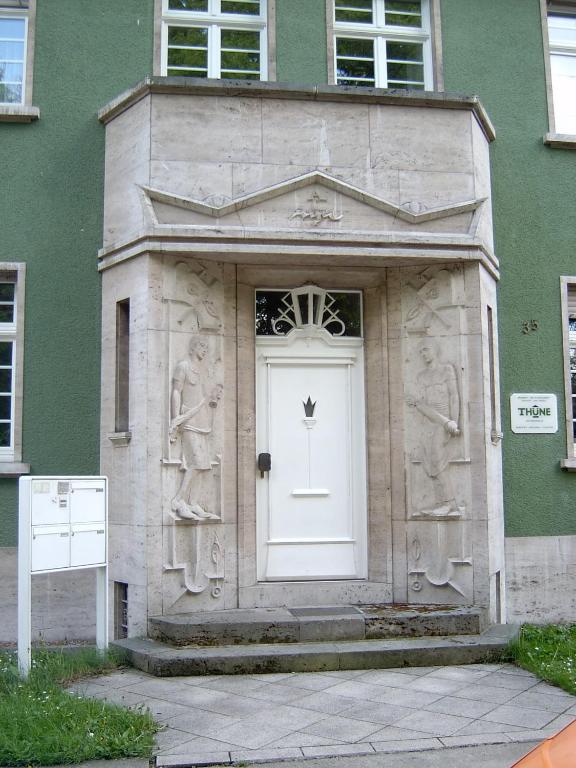 a building with a white door with statues on it at Apartmenthaus Villa Lindenbühl in Mühlhausen
