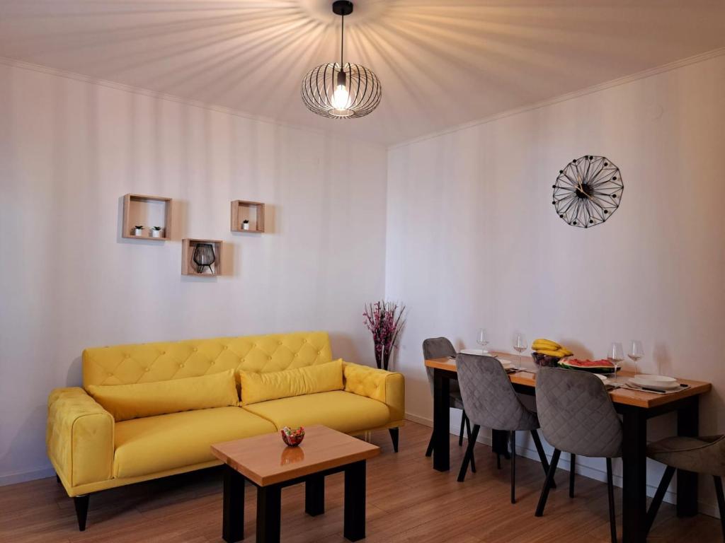 uma sala de estar com um sofá amarelo e uma mesa em Apartment Donna Cavtat em Zvekovica