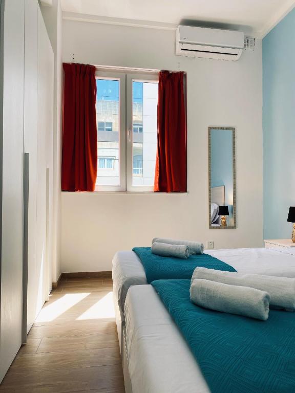 two beds in a room with red curtains at Miami Apartments in St. Julianʼs