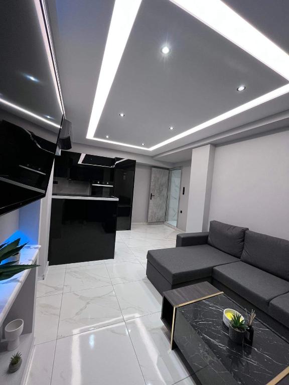 a living room with a black couch and a kitchen at The Absolute Luxury Apartment in Kalamata