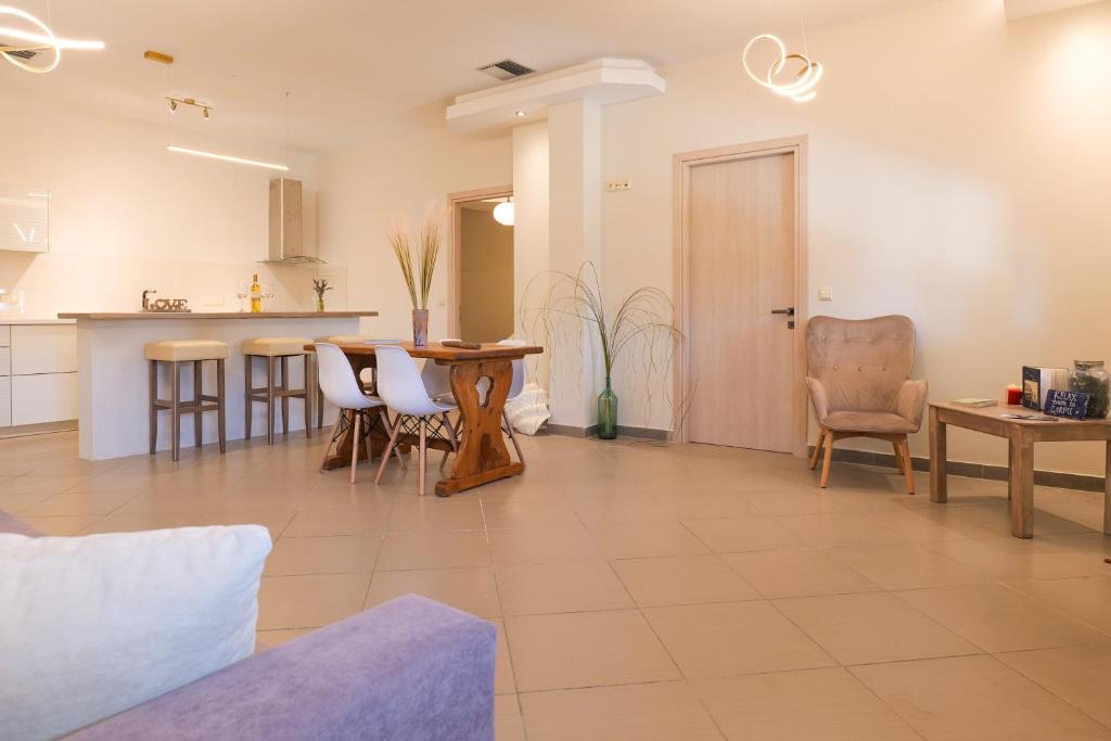 eine Küche und ein Wohnzimmer mit Tisch und Stühlen in der Unterkunft Mirabilia deluxe apartment in Arillas