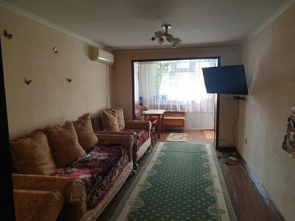 a living room with a couch and a television at Квартира in Samarkand