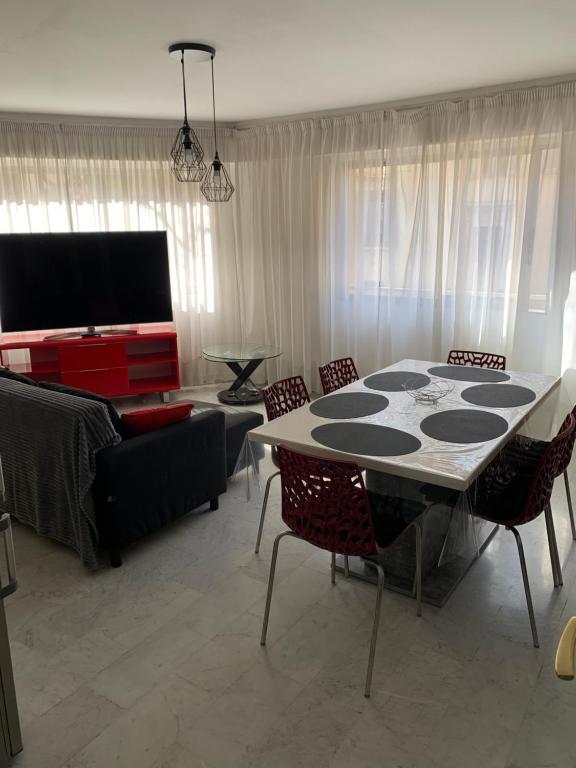 un salon avec une table, des chaises et un canapé dans l'établissement Centre cannes grand 3 pièces tout à pieds, à Cannes