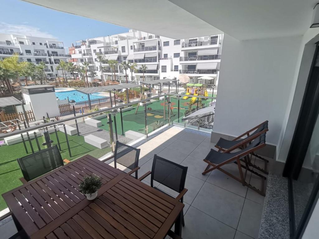 a balcony with a table and a view of a pool at Playa & Golf Deluxe en Playa Granada in Motril