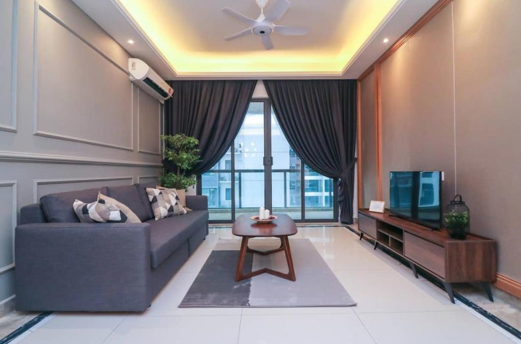 een woonkamer met een bank en een tv bij R&F Princess Cove @ UHA in Johor Bahru