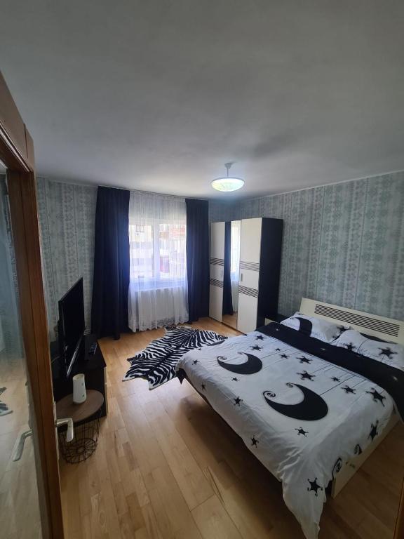 a bedroom with a large bed and a television at Garsoniera Slanic-Moldova in Slănic-Moldova