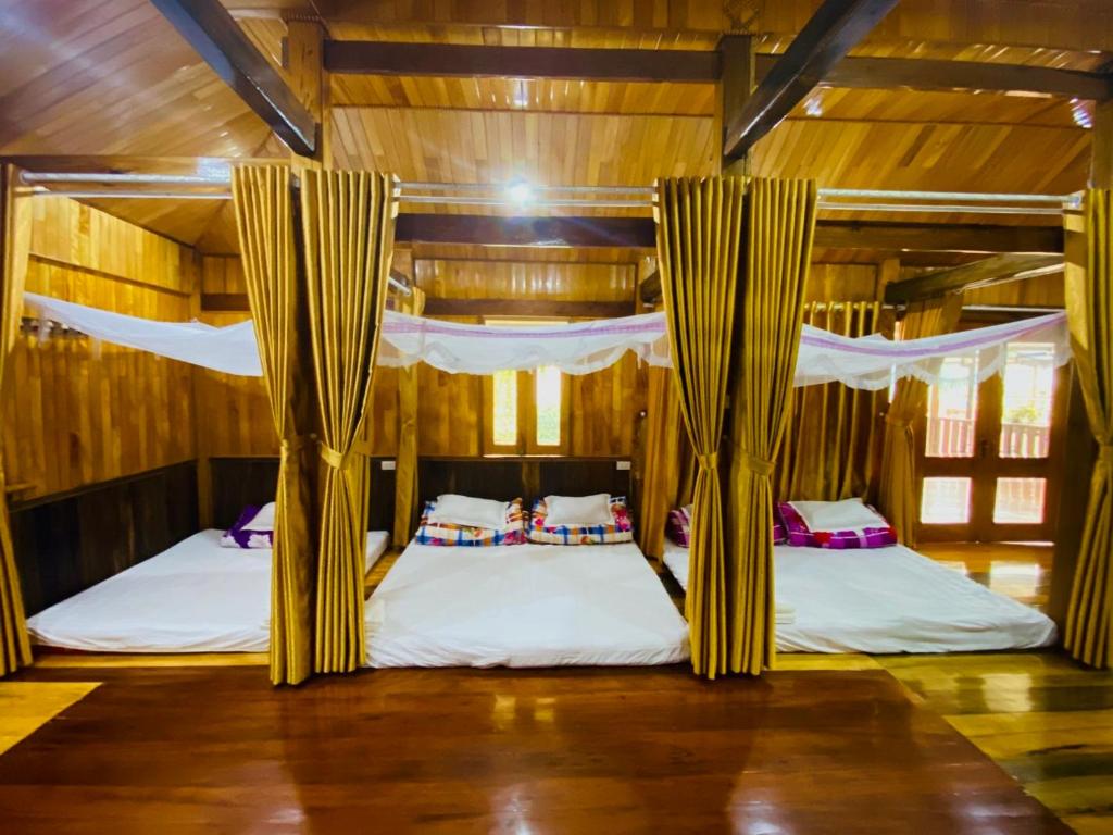 2 łóżka piętrowe w pokoju z drewnianymi ścianami w obiekcie Thai Culture Homestay w mieście Mù Cang Chải