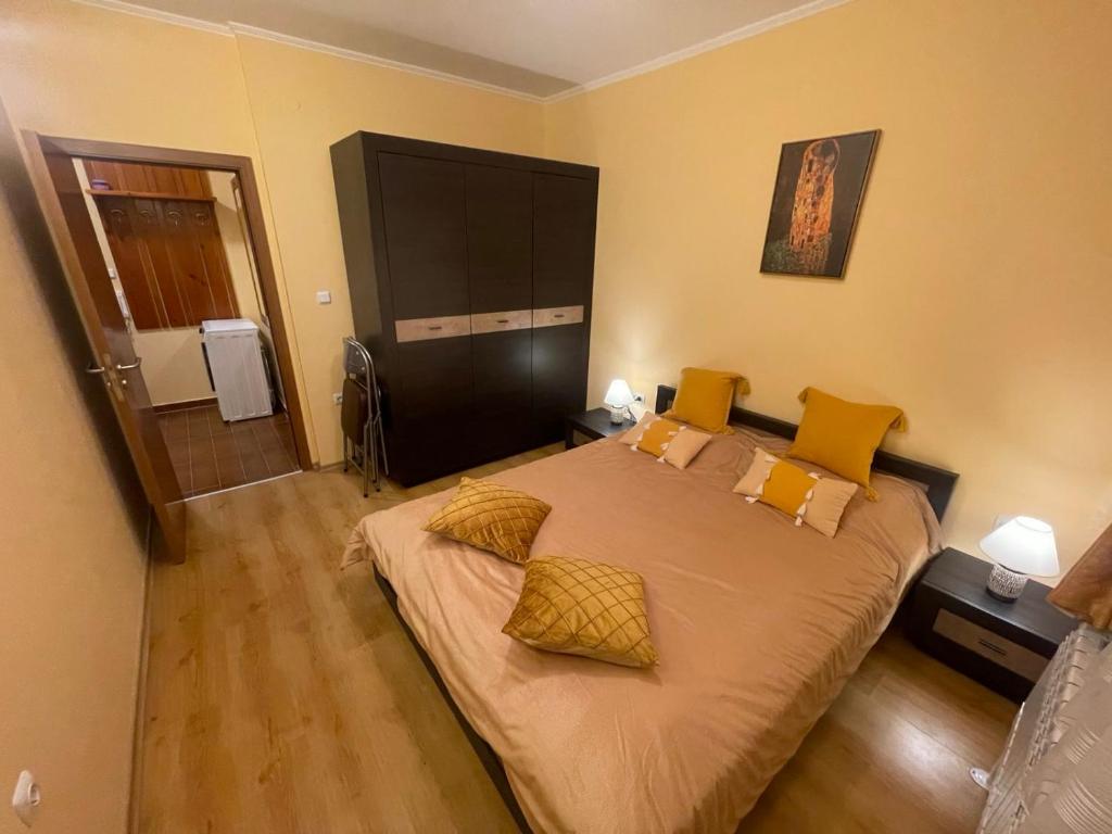 1 dormitorio con 1 cama grande con almohadas amarillas en Ski-in ski-out Fantastic Apartament en Bansko