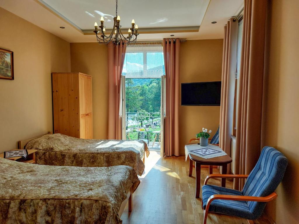 a hotel room with two beds and a window at Apartament Pułaskiego in Krynica Zdrój