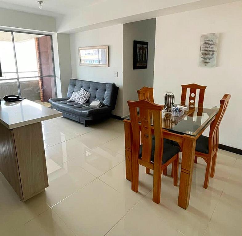 een woonkamer met een tafel en stoelen en een bank bij Cómodo y familiar apartamento en Niquia in Bello