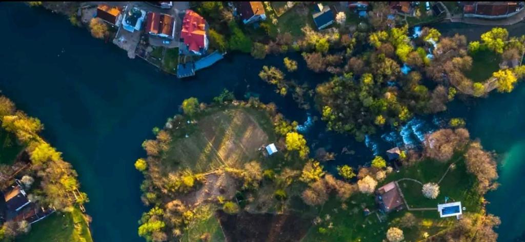 uma vista aérea de uma casa numa ilha num rio em 8 bedrooms 7 bath riverside Villa Bihac Bosnia em Golubić