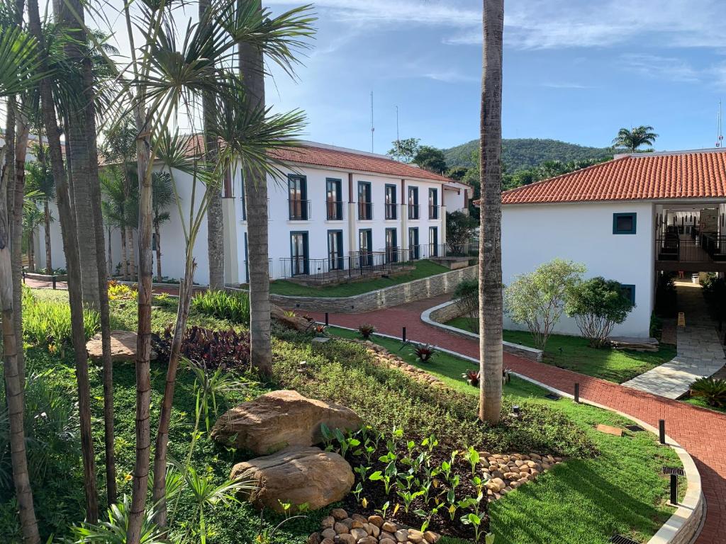 un cortile con palme e un edificio di Quinta Santa Bárbara Pirenópolis a Pirenópolis