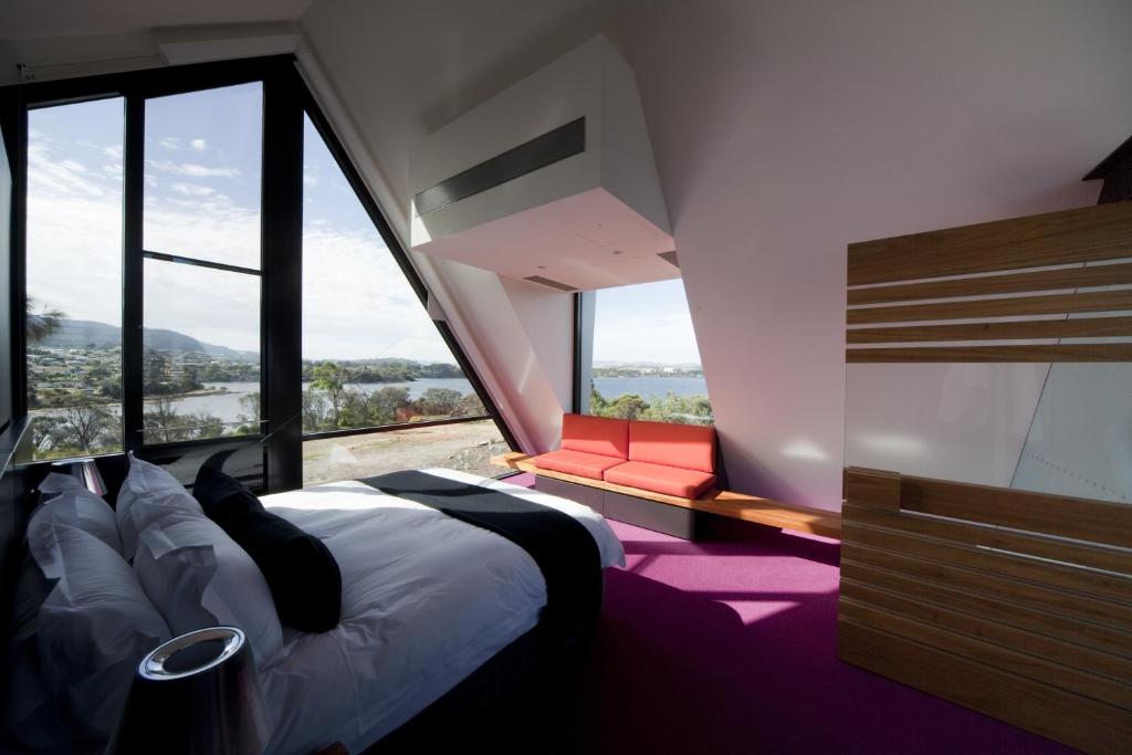 a bedroom with a bed and a large window at MONA Pavilions in Hobart