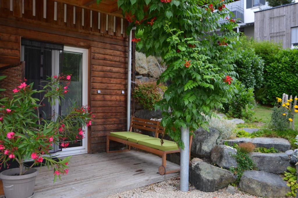una panchina seduta sul portico di una casa di Kleine Ferienwohnung für Zwei zwischen Allgäu und Bodensee 