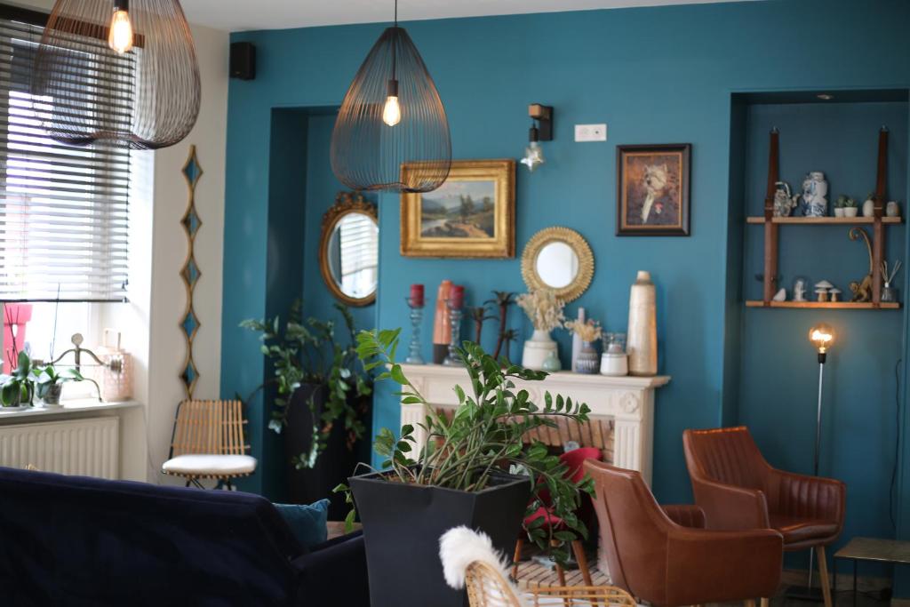 Sala de estar azul con sofá y sillas en Logis Hôtel Le Cheval Noir, en Argenton-sur-Creuse