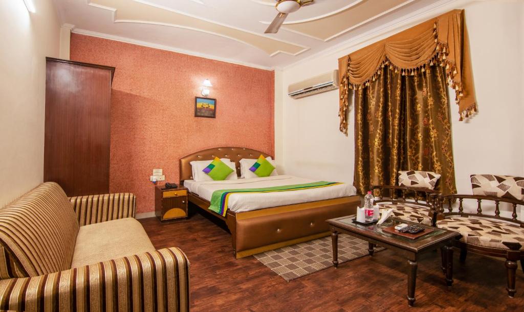 a hotel room with a bed and a couch at Treebo Trend Paras International in New Delhi
