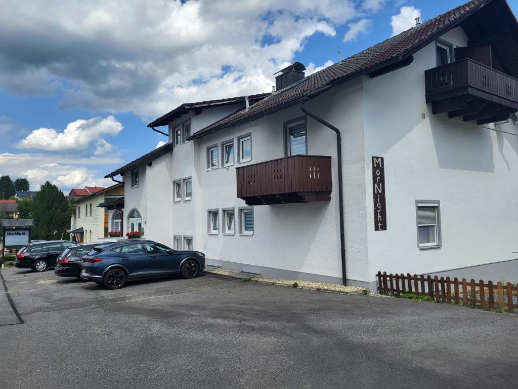 a car parked in front of a white building at MorNight in Spiegelau