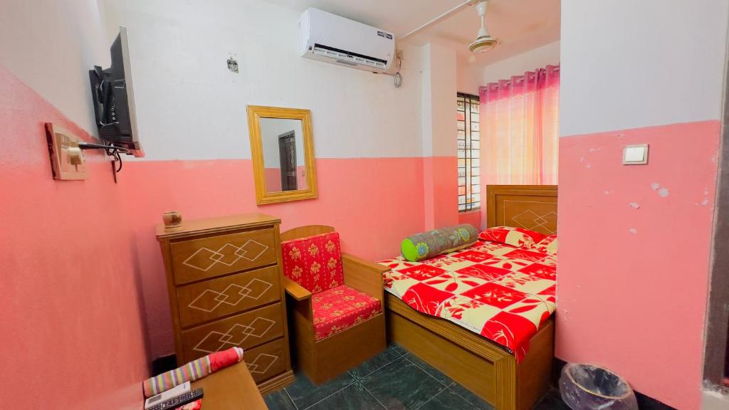 een kleine slaapkamer met een bed en een stoel bij Hotel Rose Haven Residential in Dhaka