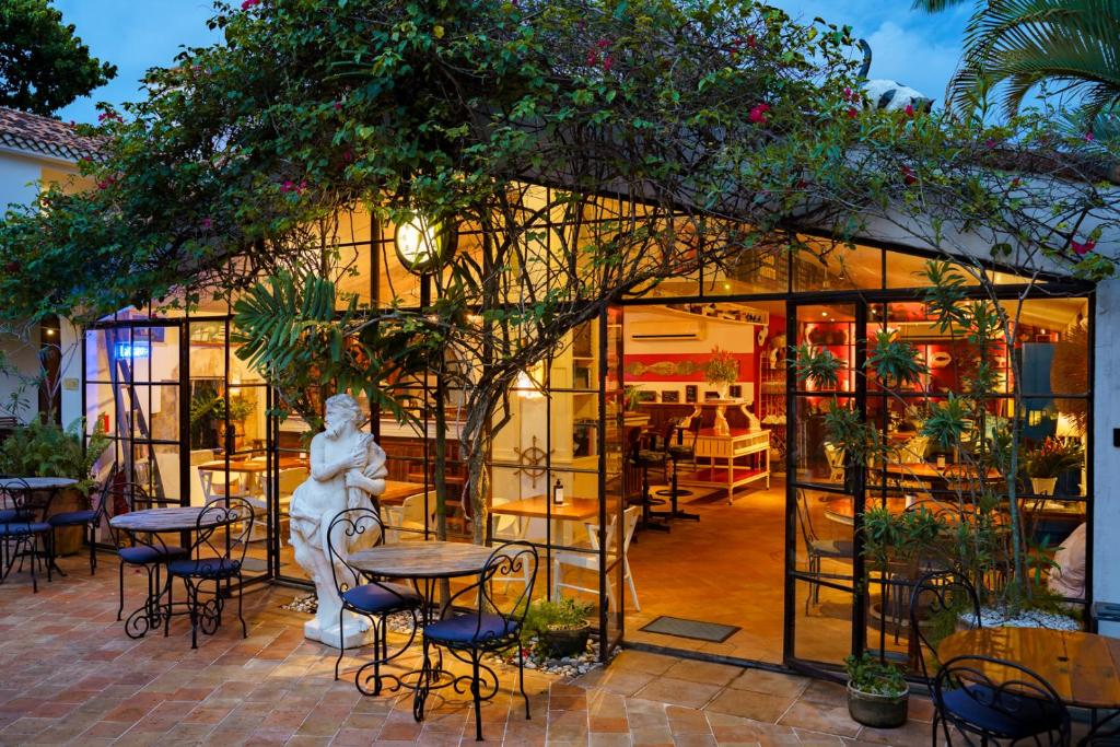 un restaurant avec une statue en face d'un bâtiment dans l'établissement Vila da Santa Hotel Boutique & Spa, à Búzios