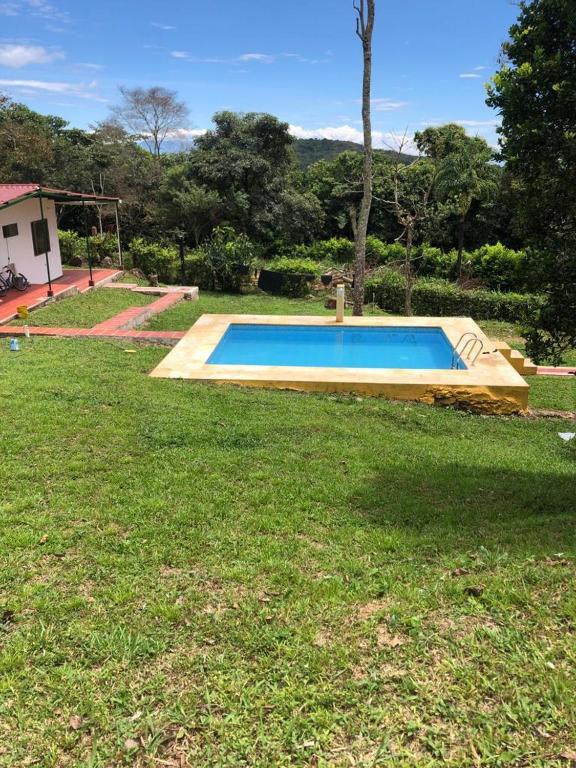 a swimming pool in the middle of a yard at Hermosa Finca de descanso en Villa Samaria a 35 minutos de Melgar in Melgar