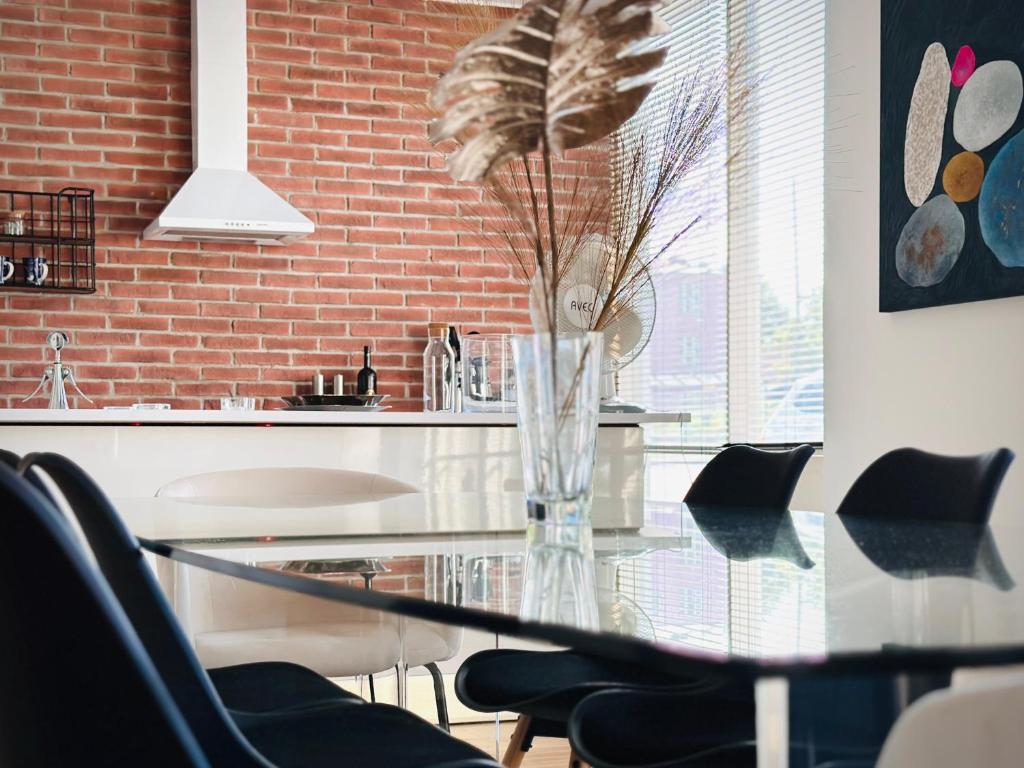 a glass table with a vase with a plant in it at Lomahuoneisto Wanha Vääksy in Vääksy