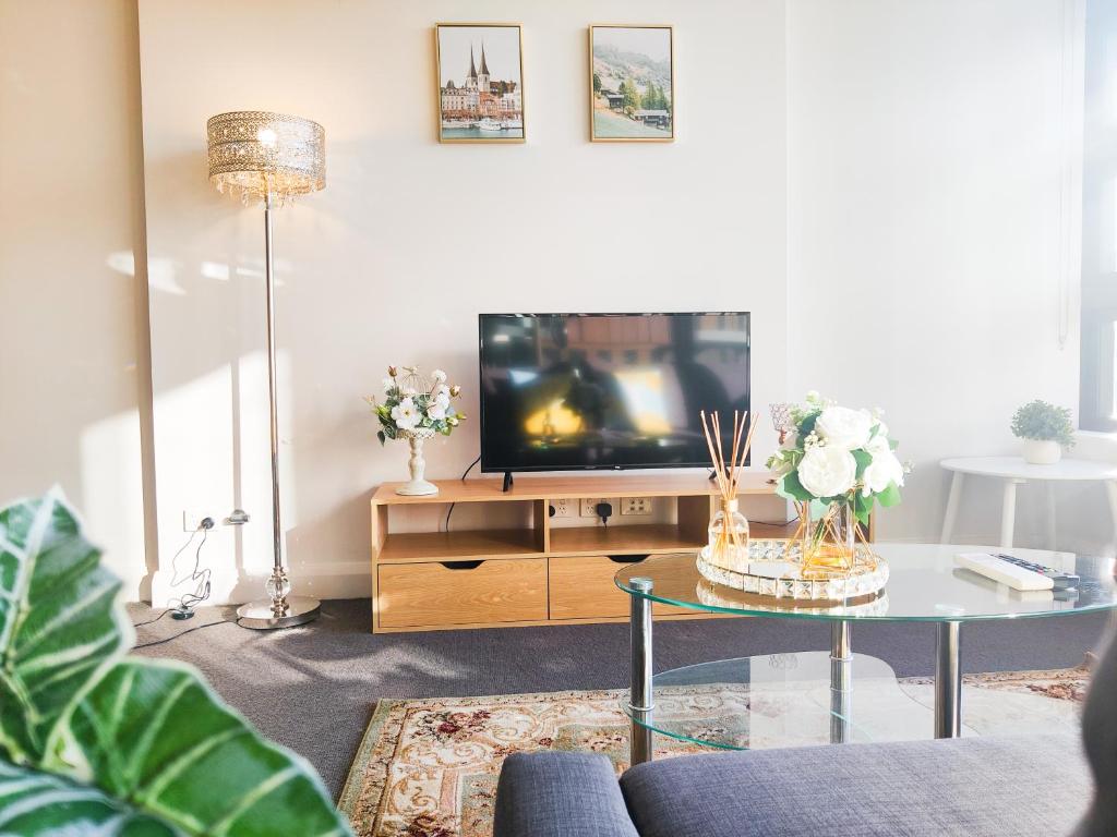 uma sala de estar com uma televisão e uma mesa de centro em Comfy & Bright 1 Bed Apt Olympic em Sydney