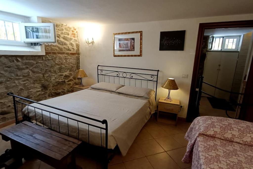 1 dormitorio con cama y pared de piedra en Taverna abitazione a 15 km da Firenze, en Prato