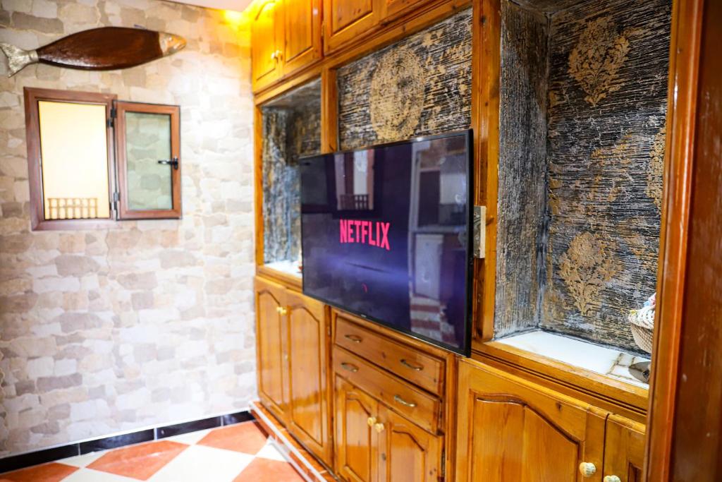 a tv in a wooden cabinet in a room at Salam appartement in Azrou