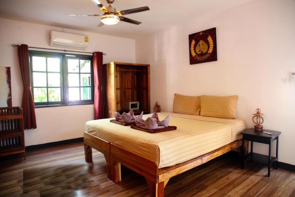 ein Schlafzimmer mit einem großen Bett und einem Deckenventilator in der Unterkunft Tropical Village Resort in Koh Samui 