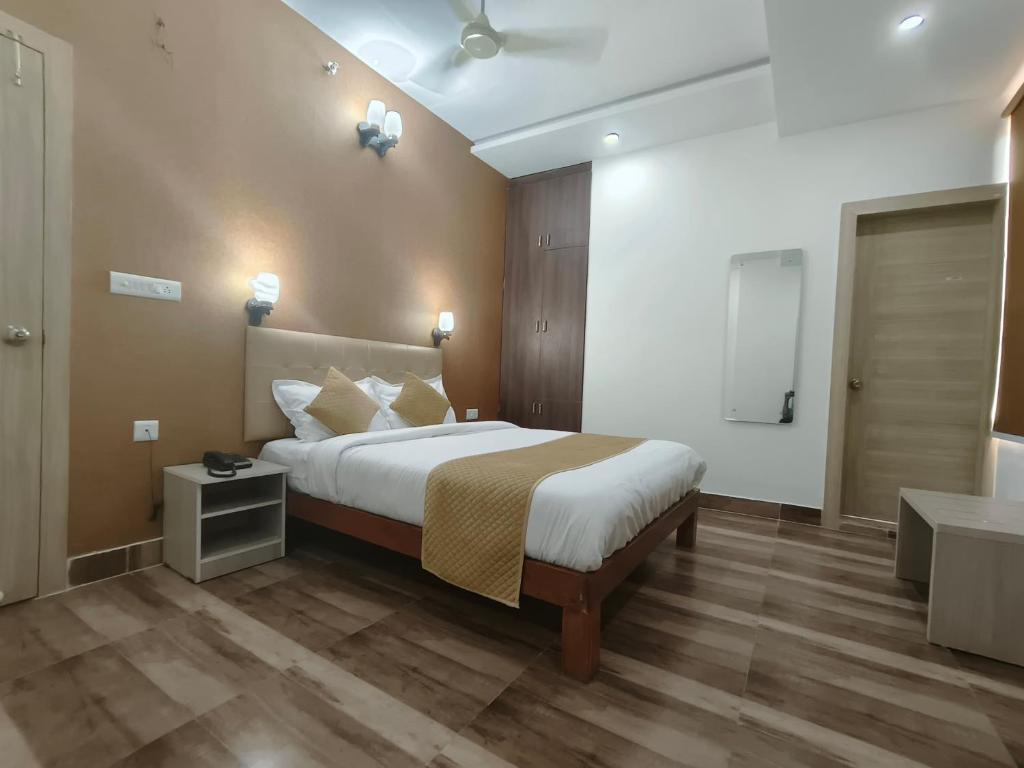 a bedroom with a large bed and a bathroom at Pink Vista Hotel in Jaipur
