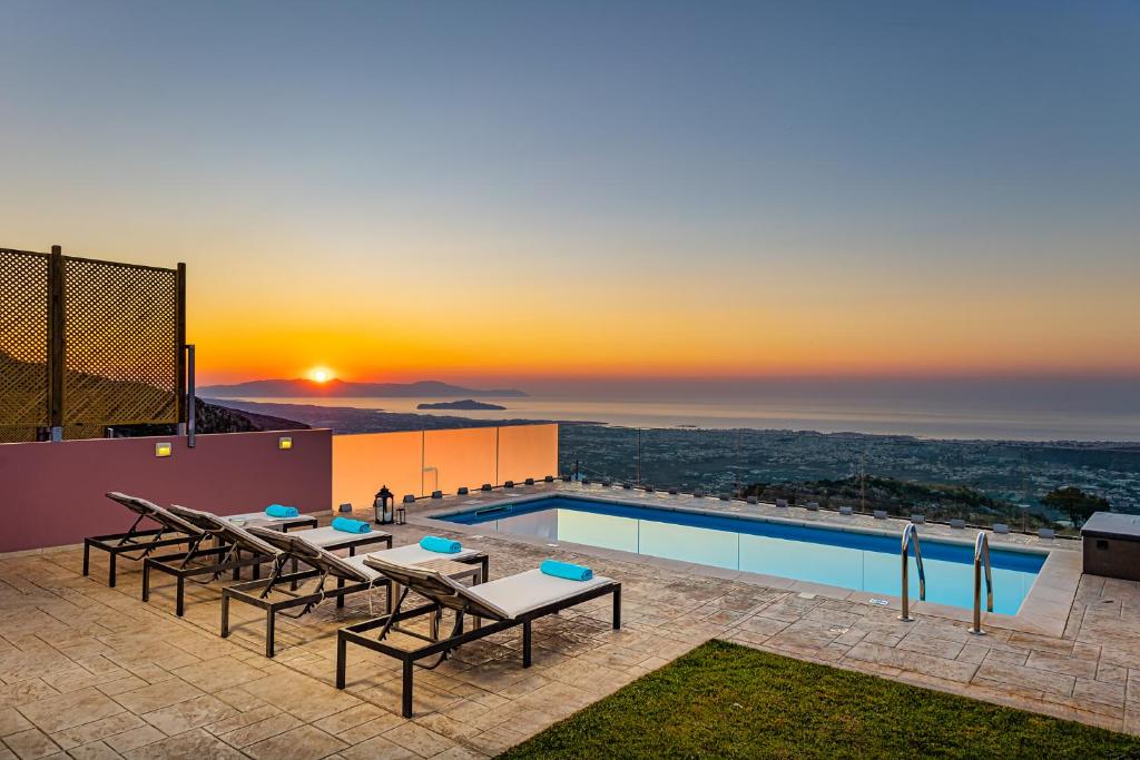 a pool on top of a building with a sunset at Villa Nektar with private ecologic pool and amazing view! in Kondópoula