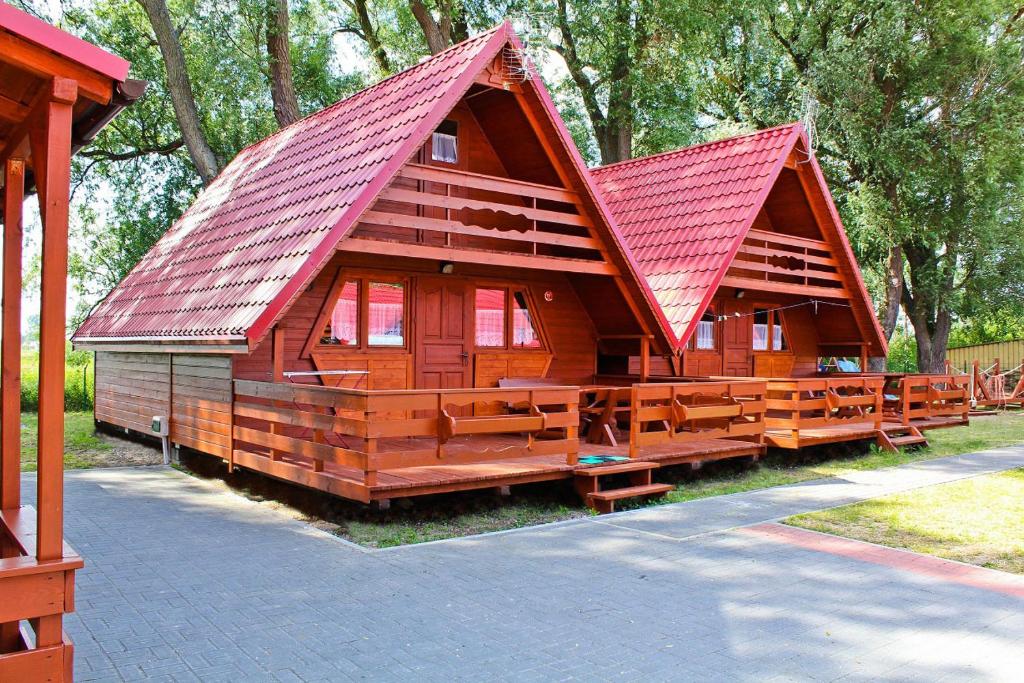 duża drewniana kabina z czerwonym dachem w obiekcie Domki letniskowe Ibiza w Dźwirzynie
