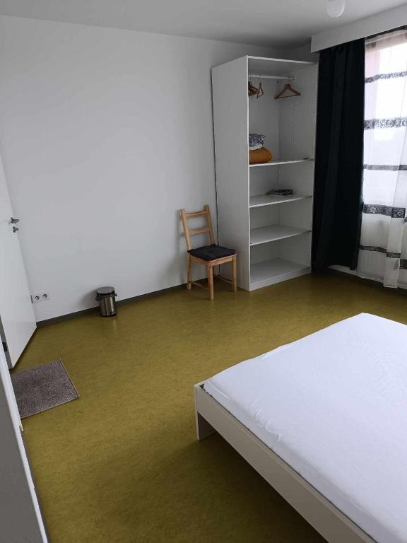 una camera con un letto e una sedia di Chambre avec douche privé a Bruxelles