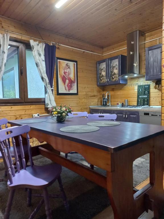 a kitchen with a large wooden table and chairs at Wooden house in Hondol