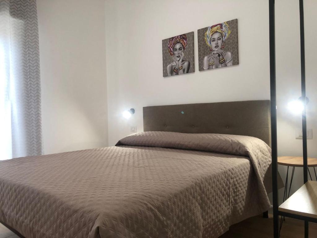 ein Schlafzimmer mit einem Bett und zwei Bildern an der Wand in der Unterkunft Mediterranea Apartment in Trapani
