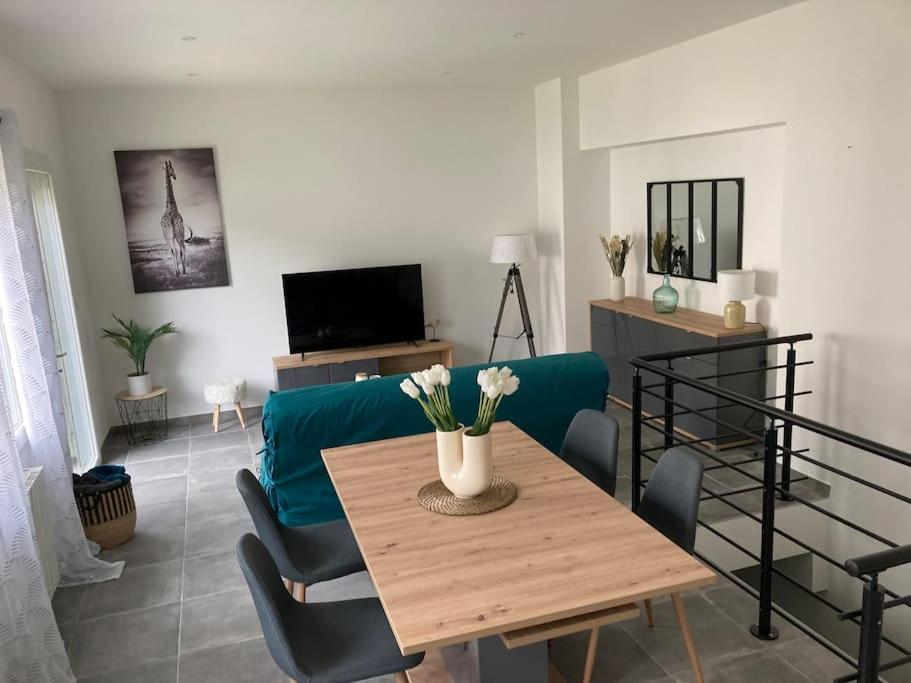 un salon avec une table et un canapé bleu dans l'établissement L’Atelier du Puits Volant, à Meximieux