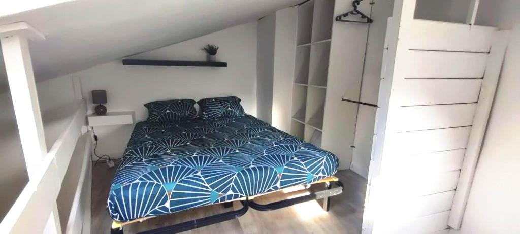 a bedroom with a bed with blue and white sheets at Studio de caractère à Orange in Orange