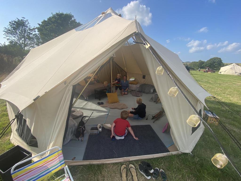a group of people sitting inside of a tent at Bell Tents at Llanfair Hall in Llanfairpwllgwyngyll