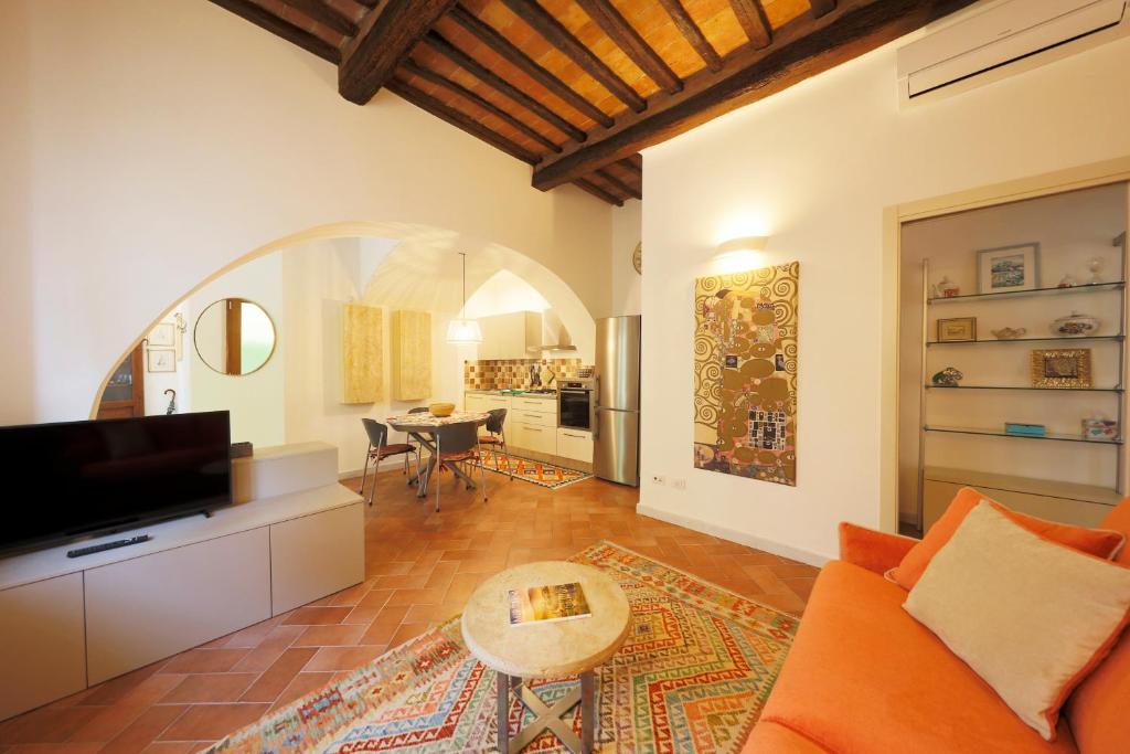 un salon avec un canapé orange et une table dans l'établissement Siena UpTown - Sabrina's Lovely Apartment, à Sienne