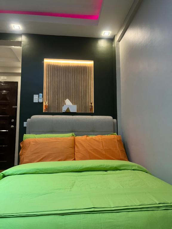 sypialnia z dużym łóżkiem z pomarańczową poduszką w obiekcie Oppas Studio Unit near Sm uptown w mieście Cagayan de Oro