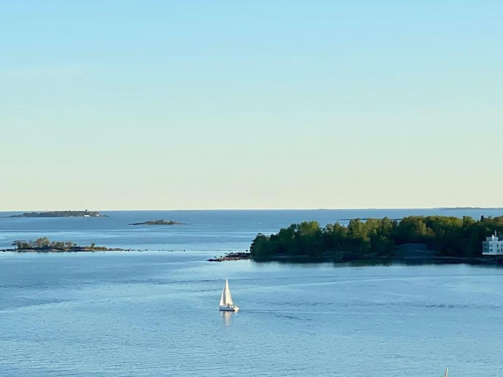 um veleiro no meio de um grande corpo de água em Goldfinger saunallinen kaksio merinäköalalla 11 krs em Helsinque