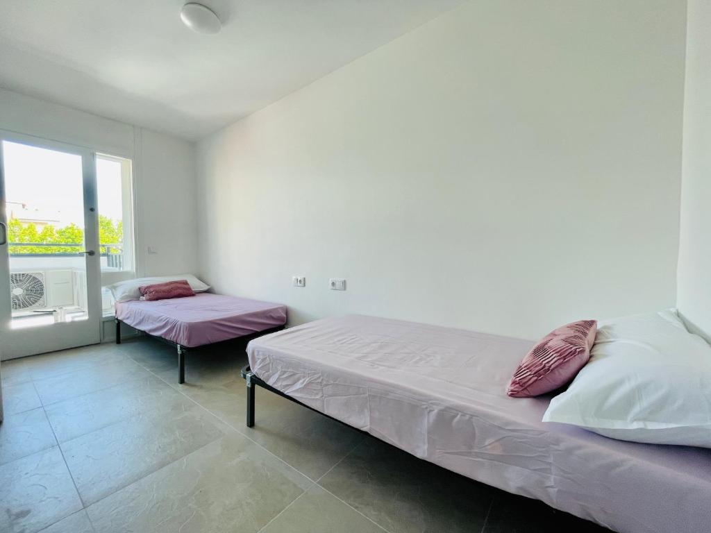 een slaapkamer met twee bedden en een raam bij MALTA LUXE in Salou