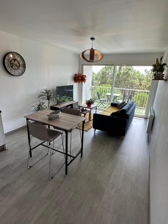 ein Wohnzimmer mit einem Tisch und einem Sofa in der Unterkunft Appartement au bord de mer in Saint-Brevin-les-Pins