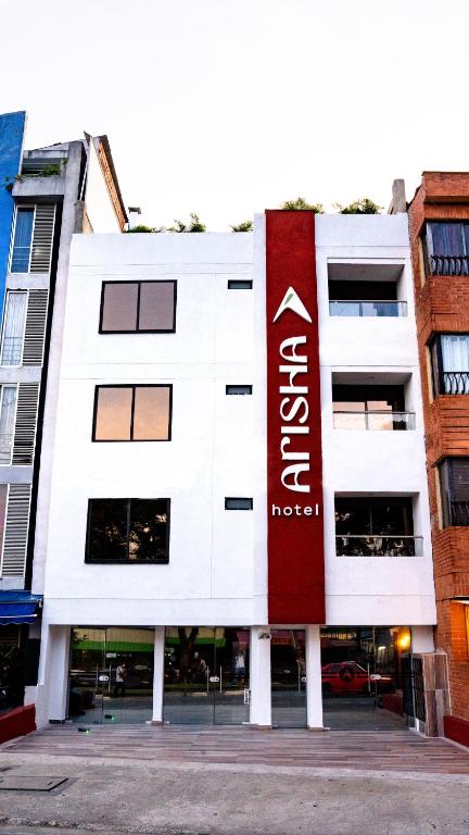 a white building with a red sign on it at Hotel Arisha Cali in Cali