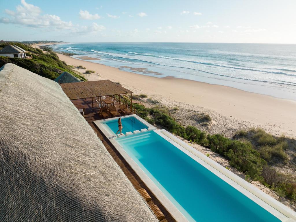 an overhead view of a swimming pool next to a beach at Kumba Lodge in Praia do Tofo